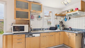 Eine Küche mit Holzausstattung, einer Mikrowelle, einem Spülbecken und einem Fenster.