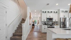 A kitchen with white cabinets, a stainless steel refrigerator, a microwave, and a stove. - Fin and Tonic - Private Pool + 6 Bikes (Inlet Beach)