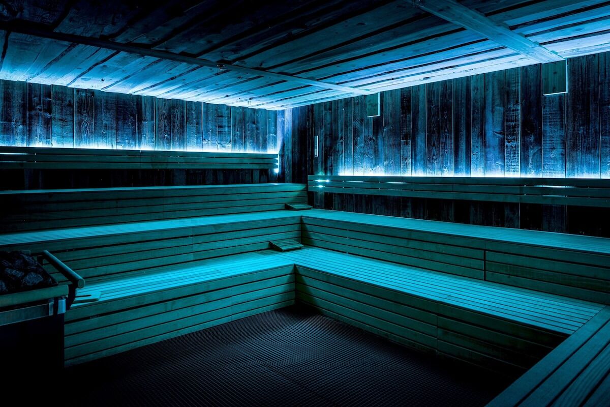 A sauna with wooden benches and a sloped ceiling.