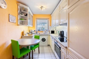 Cocina compacta con lavadora, microondas y pileta.