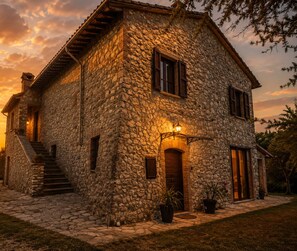A stone house with a staircase, a wooden door, and a potted plant. - ✨ Casale Caserinzio - Camellia (avigliano umbro)
