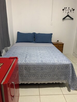 A bedroom with a bed, a nightstand, a red cabinet, and a wall-mounted coat rack. - Full suite with air conditioning and mini-bar next to Beto Carrero World (Penha)