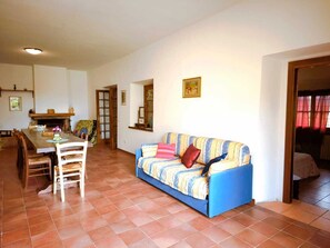 A living room with a sofa, chairs, a dining table, and a fireplace. - Casale Caserinzio | Nature, History and Relaxation in the Heart of Umbria (Avigliano Umbro, Terni)