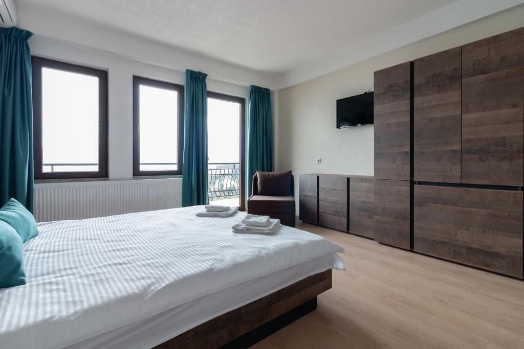 Un dormitorio con cama, una silla, televisor y armario.