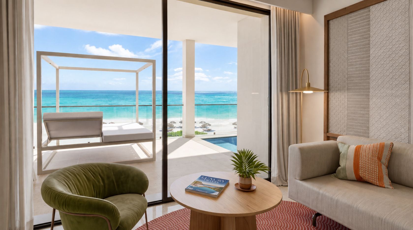 Une pièce avec vue sur l’océan, un fauteuil vert, un canapé, une table ronde avec un livre et une plante, et une porte-fenêtre coulissante donnant sur un balcon avec une piscine.