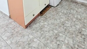 Een kamer met een inbouwkast, een koelkast en een betegelde vloer.