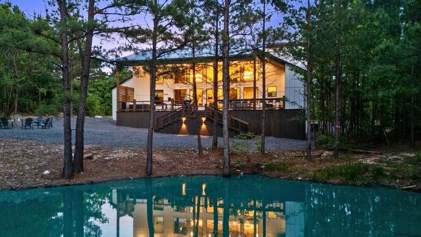 Eine Lodge mit Pool, umgeben von Bäumen, und einer Treppe, die zum Eingang führt.