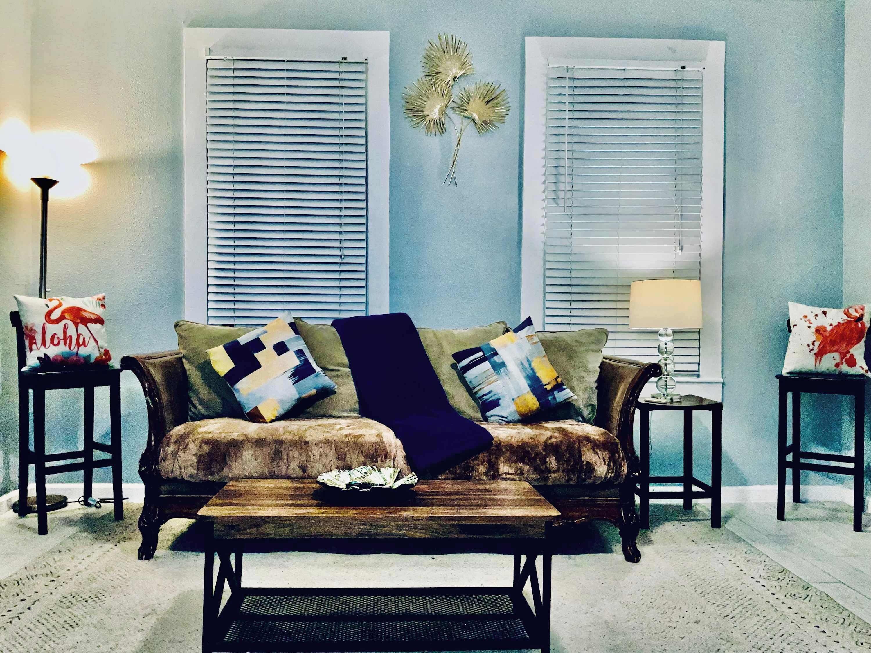 A living room with a sofa, a coffee table, and two side tables.