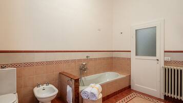 Une salle de bain équipée d’une baignoire, d’un bidet et de toilettes.
