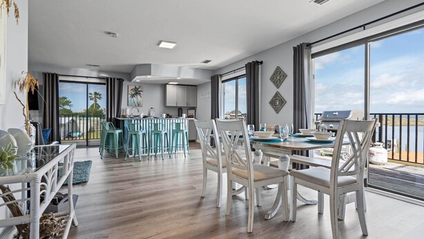 Un comedor amplio con un gran ventanal, una cocina con vistas y un balcón también con vistas.