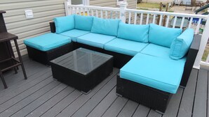 A deck with a sectional sofa and a glass coffee table. - Cozy Wildwood House, Great Location, Private Parking, Walking distance to beach (Wildwood)