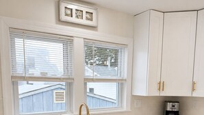 A kitchen with white cabinets, a stainless steel dishwasher, and a coffee maker. - Cozy Wildwood House, Great Location, Private Parking, Walking distance to beach (Wildwood)