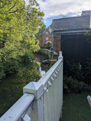 Ein Wohngebiet mit einem Fluss, einer Brücke und einem Haus mit Ziegeldach.