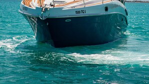 A boat with a cabin and a deck, moving through turquoise water. - Dream boat (Tunis)
