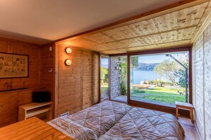 Ein Zimmer in einer Holzhütte mit einem Bett, einem kleinen Tisch und einem Fernseher.