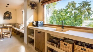 Eine Küche mit großem Fenster, Holzschränken und gewebten Körben.