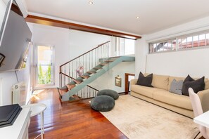 A modern living room with a wooden staircase, a sofa, and a radiator. - Villa Havana - Five Bedroom Villa, Sleeps 12 (Quint Mar)