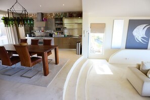 Eine moderne Küche mit Essbereich, einer Couch und einem Gemälde.