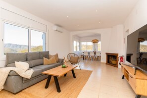 Ein modernes Wohnzimmer mit einer Couch, einem Couchtisch und einem Essbereich mit Stühlen.