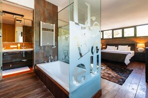 Ein modernes Badezimmer mit einer großen Badewanne, einer Glasabtrennung und einer separaten Duschkabine.