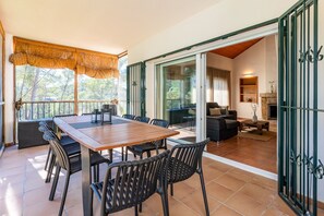 Un espacio abierto que combina sala de estar con comedor, con mesa, sillas, sofá y chimenea.