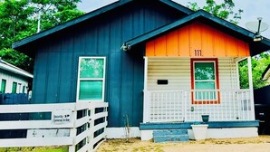 A two-story building with a blue exterior and an orange front. - Stylish Downtown Cottage near Alamodome, Hemisphere & Riverwalk (San Antonio)