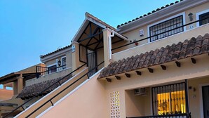 Un immeuble résidentiel doté d’un escalier, d’un balcon et d’une porte.