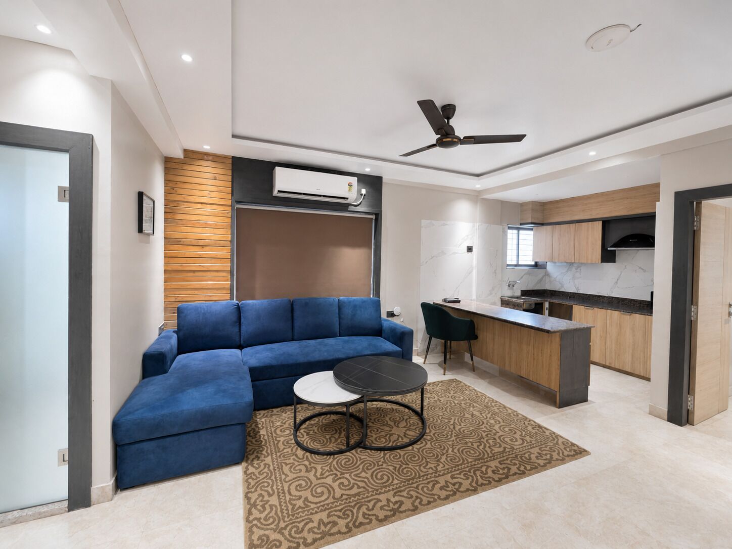 A modern living room with a blue sofa, a small round table, and a patterned rug.