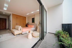 Ein modernes Schlafzimmer mit einem Bett, einer Couch und zwei Sesseln.