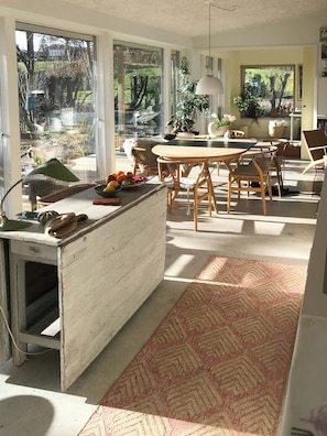 A spacious kitchen with a large island, wooden chairs, and a dining table. - Architect-designed wooden house near beach (Odder)