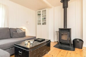 A living room with a sofa, a coffee table, a fireplace, and a cabinet.