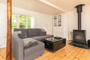 A living room with a sofa, a coffee table, a fireplace, and a wooden floor.