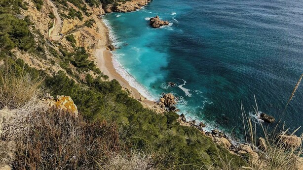 A coastal landscape with a winding road, rocky cliffs, and a beach. - Ibiza-style villa in Jávea near beach with pool (Jávea)