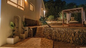 A stone-walled outdoor area with a pergola, potted plants, and a shower. - Ibiza-style villa in Jávea near beach with pool (Jávea)