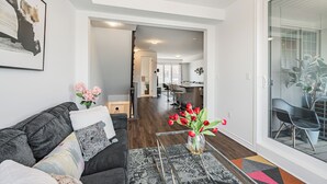 Een moderne woonkamer met een bank, een salontafel en een vaas met bloemen.