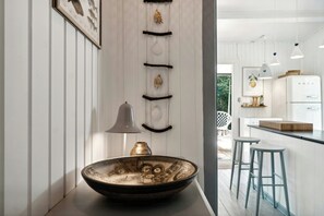 Una cucina moderna con un lavello grande, luci a sospensione e un frigorifero.