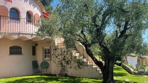 A house with a red roof, a large tree in the front yard, and a stone pathway. - Exceptional apartment in Cannes' countryside (Spéracèdes)