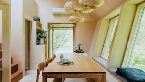 Une table à manger en bois, des chaises, un banc de fenêtre et une lucarne.