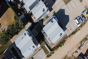 Una zona residenziale con diverse case, un parcheggio e una spiaggia sabbiosa.