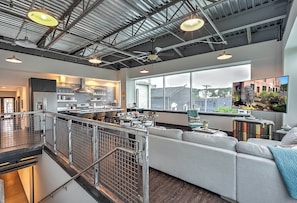 Eine geräumige Loft-Wohnung mit Küche, Wohnbereich und großen Fenstern mit Blick auf die Stadt.