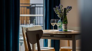 A table with a bottle of Blanc Pescador wine, two glasses, and a vase of flowers. - New holiday home by the sea (Jastrzębia Góra)