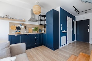 Eine moderne Küche mit blauen Schränken, Holz Arbeitsplatten und einer Pendelleuchte.