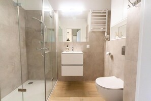 A modern bathroom with a glass shower enclosure, a white sink, and a toilet. - Dziwnów Couples Stay with Panoramic Views (Dziwnow)