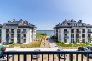 Un immeuble résidentiel offrant une vue sur la mer, doté de balcons et d’un espace de stationnement.