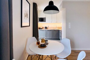 Una cocina moderna con armarios grises, un microondas y una cafetera en la encimera.