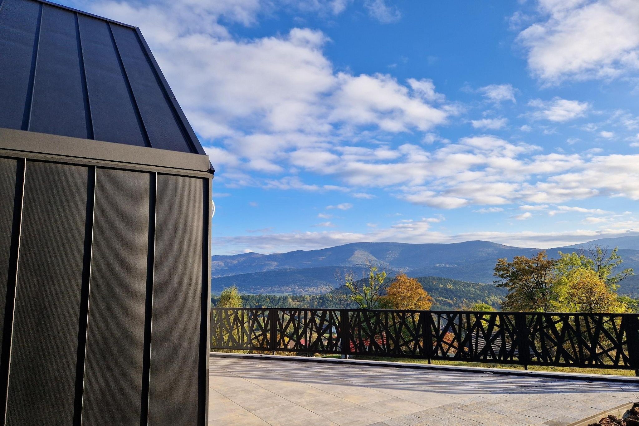 A balcony with a view of mountains and trees.