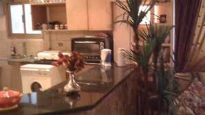 A kitchen with a stove, microwave, and a sink. There is a vase with flowers on the counter. - Central 3BR Flat in Most Classy Spot in Mohandseen (Giza Governorate)
