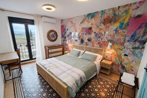 Una camera da letto con un letto, una scrivania e un balcone.