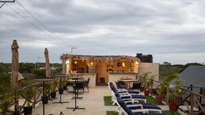 An outdoor patio with lounge chairs, tables, and umbrellas.