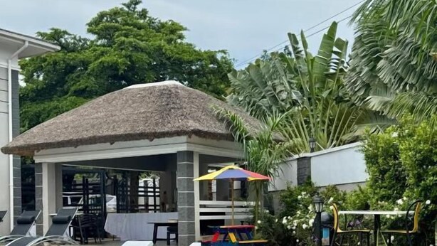 A swimming pool with lounge chairs and a covered seating area. - Annavilla7 Lilongwe Hotel (Lilongwe)